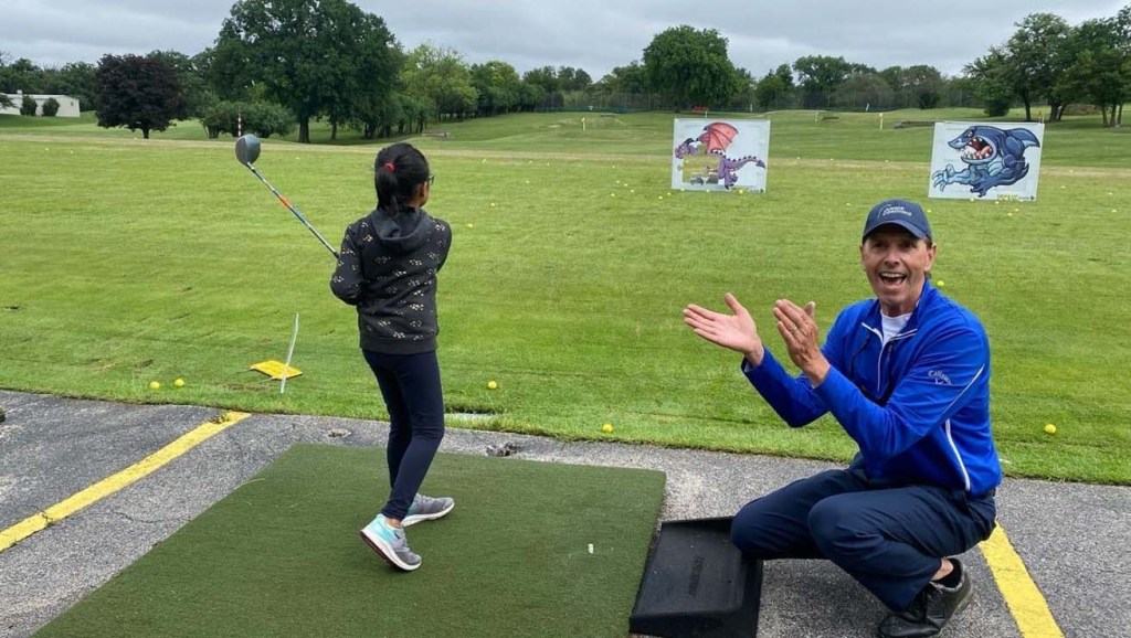 Ken Malnar teaching golf to kids.